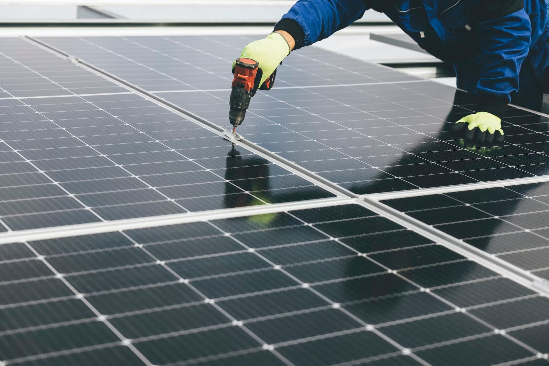Technician securing renewable energy equipment on a rooftop during home retrofit