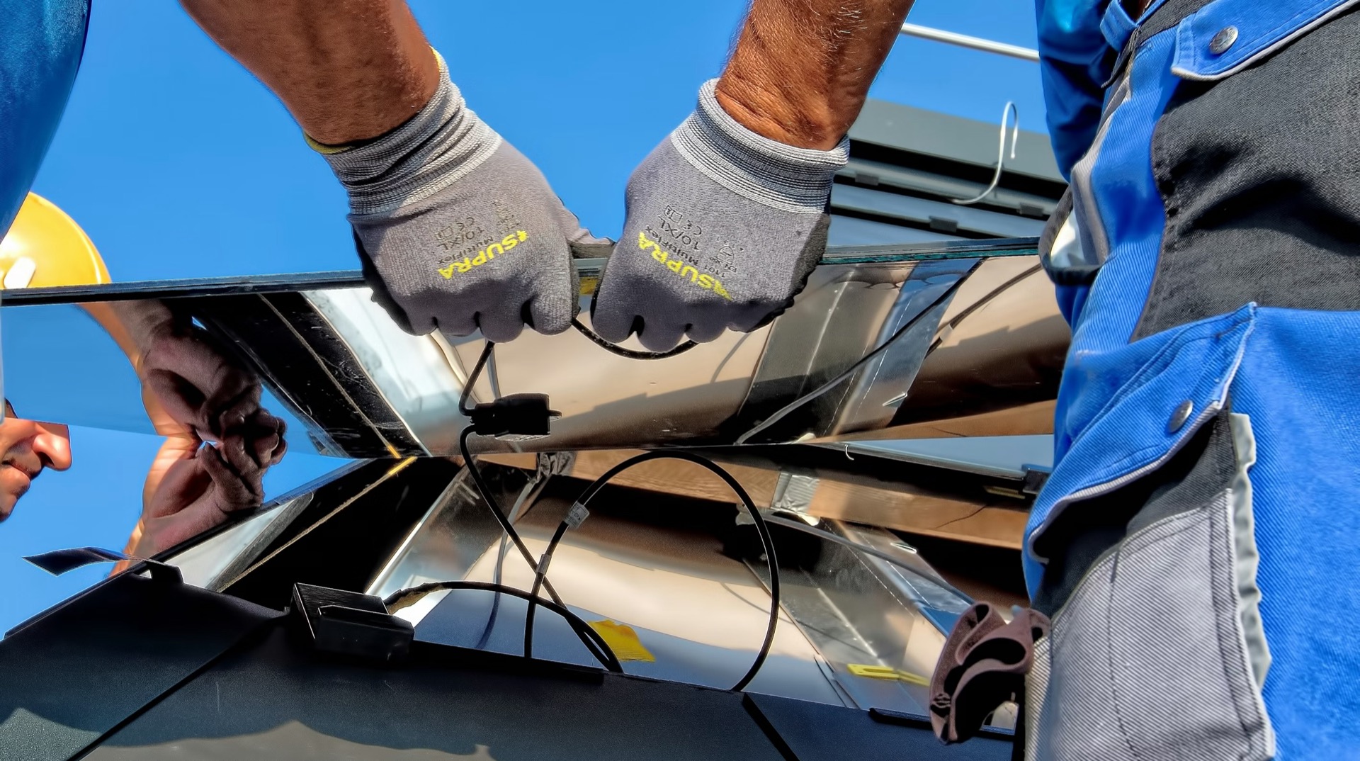 Installers fitting solar panels on a rooftop close-up